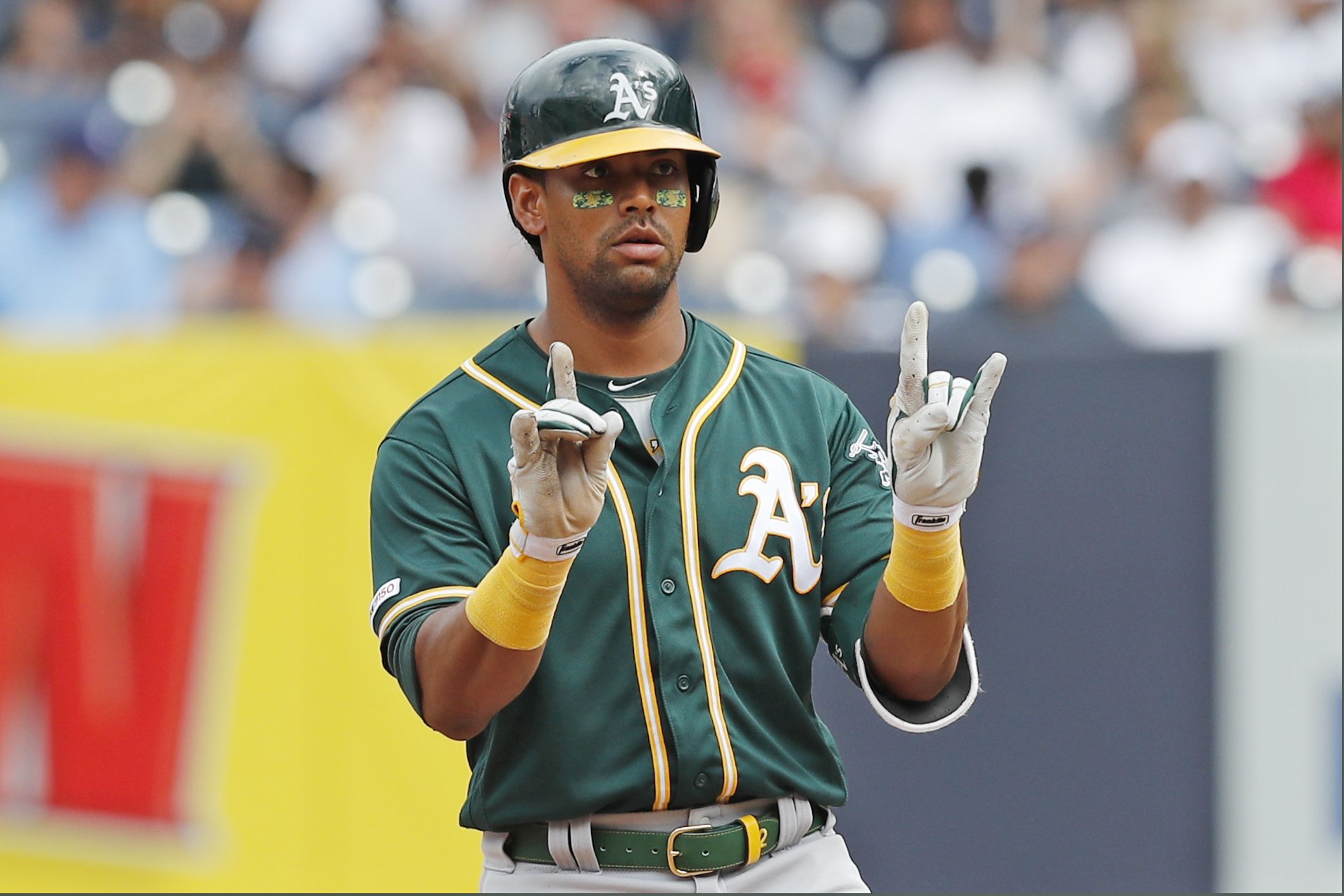 Oakland Athletics designated hitter Khris Davis gestures to his teammates after hitting a double in the top of the seventh inning of a baseball game against the New York Yankees, Sunday, Sept. 1, 2019, in New York. (AP Photo/Kathy Willens)