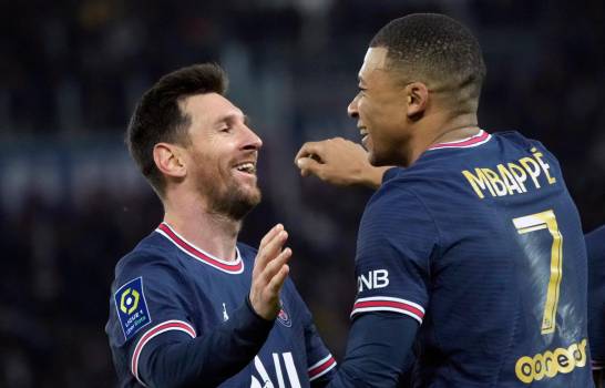 Kylian Mbappe (centro) del Paris Saint-Germain celebra con Lionel Messi tras marcar un gol ante Mónaco en la liga francesa, el domingo 12 de diciembre de 2021. (AP Foto/Christophe Ena).