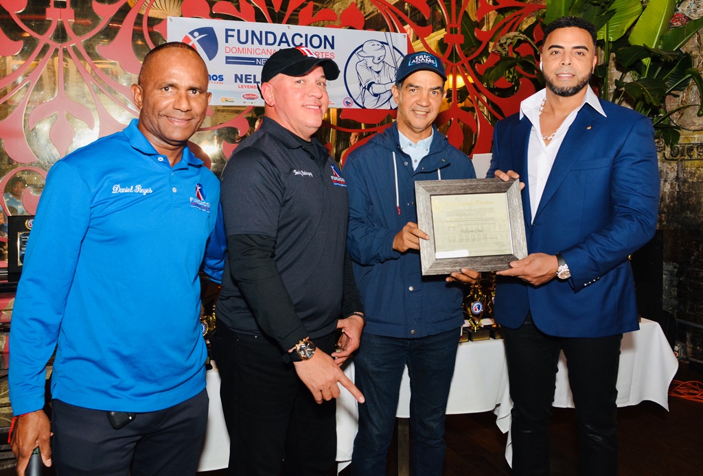Ydanis Rodríguez a nombre del Consejo Municipal de Nueva York premia la labor de Nelson Cruz fuera del terreno de juego. En la gráfica aparecen a la izquierda Daniel Reyes y Tenchy Rodríguez.