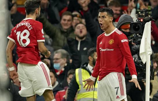 Cristiano Ronaldo (derecha) del Manchester United celebra con Bruno Fernandes tras anotar el segundo gol en la victoria 3-2 ante Arsenal en la Liga Premier inglesa, el jueves 2 de diciembre de 2021. (AP/Dave Thompson)