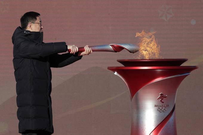 El viceprimer ministro de China, Han Zheng, enciende la antorcha olímpica antes del inicio del relevo para los Juegos Olímpicos de Invierno de Beijing 2022, en el parque olímpico de Beijing.