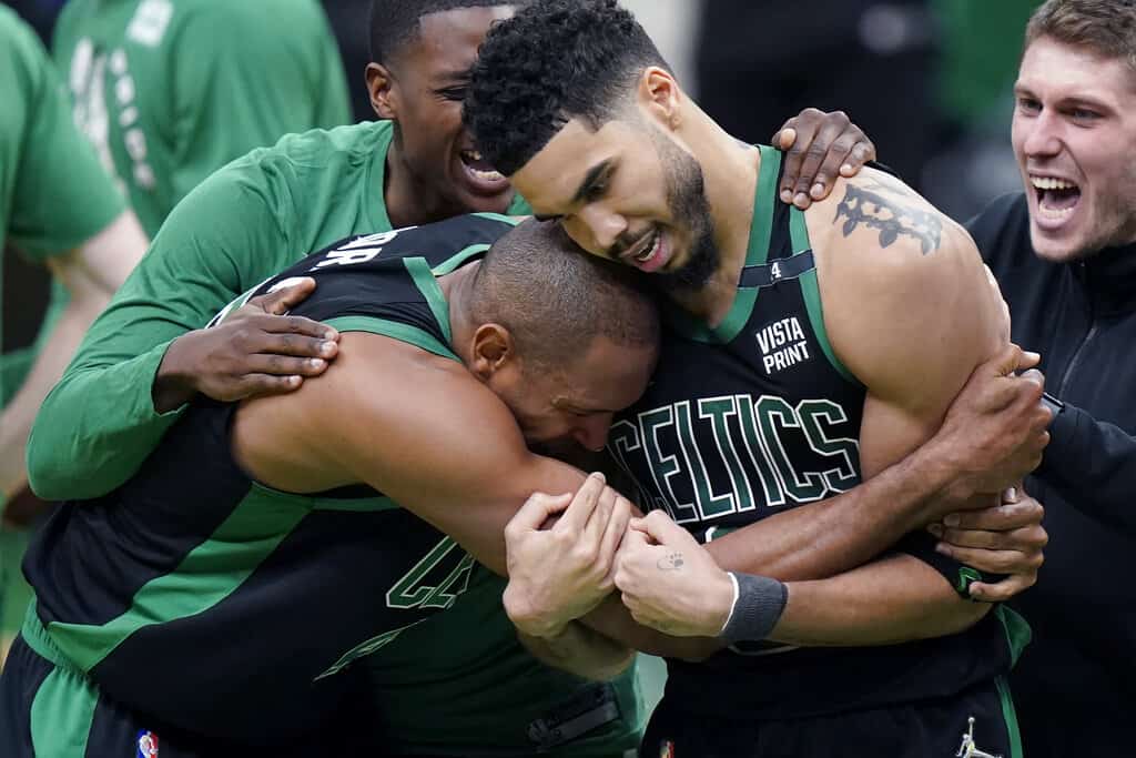 El centro de los Boston Celtics, Al Horford, al frente a la izquierda, y el alero Jayson Tatum, al frente a la derecha, celebran después de que Tatum hizo una bandeja en el timbre para anotar y ganar el Juego 1 de una serie de playoffs de la primera ronda de la Conferencia Este de baloncesto de la NBA contra los Brooklyn Nets, el domingo. 17 de abril de 2022, en Boston. Los Celtics ganaron 115-114. ( (FOTO AP/STEVEN SENNE))