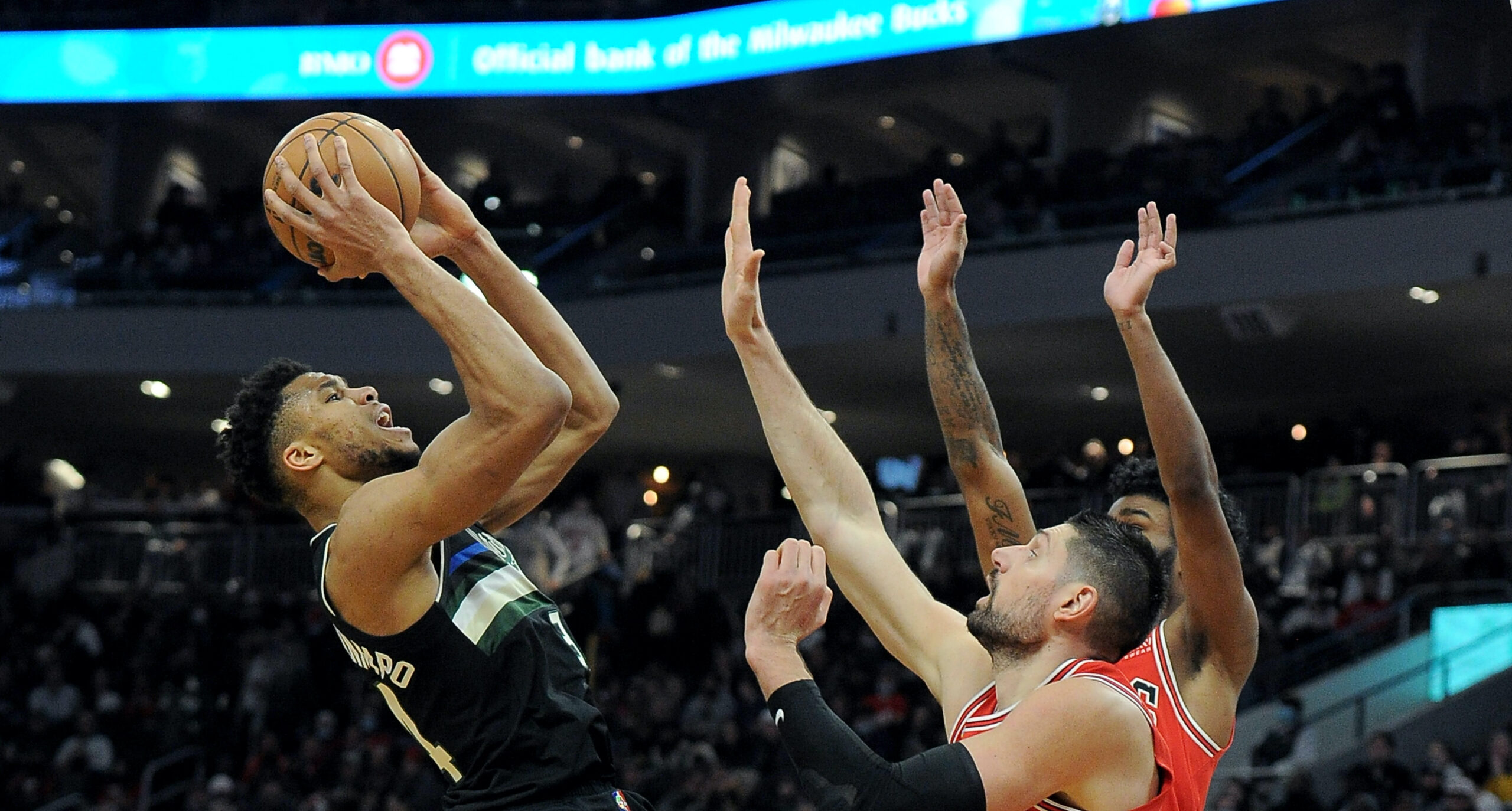 Jan 21, 2022; Milwaukee, Wisconsin, USA;  Milwaukee Bucks forward Giannis Antetokounmpo (34) puts up a shot against Chicago Bulls guard Coby White (0) and center Nikola Vucevic (9) in the second half at Fiserv Forum. Mandatory Credit: Michael McLoone-USA TODAY Sports
