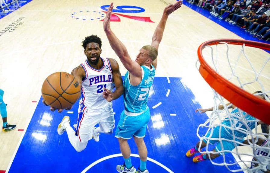 Joel Embiid de los 76ers de Filadelfia, a la izquierda, sube al tiro contra Mason Plumlee de los Hornets de Charlotte, a la derecha, el sábado 2 de abril de 2022 en Filadelfia. (AP/CHRIS SZAGOLA)