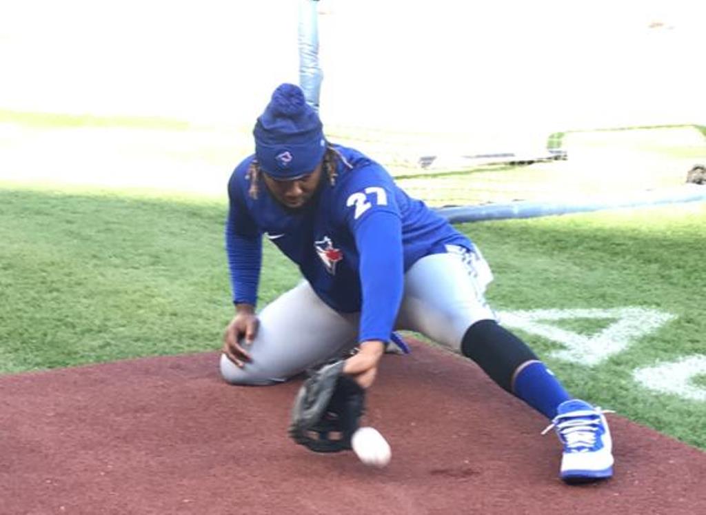 Vladimnir Guerrero Jr. ejecutando su tarea de todos los días de su juego de pies y de estirar el brazo atrapando rolata.