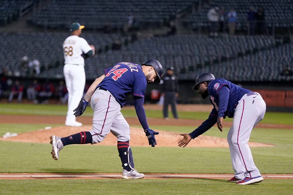 El receptor de los Mellizos, Gary Sánchez, fue felicitado por el entrenador de tercera base, Tommy Watkins, luego de conectar un jonrón en la sexta entrada el lunes por la noche. (JEFF CHIU, ASSOCIATED PRESS)