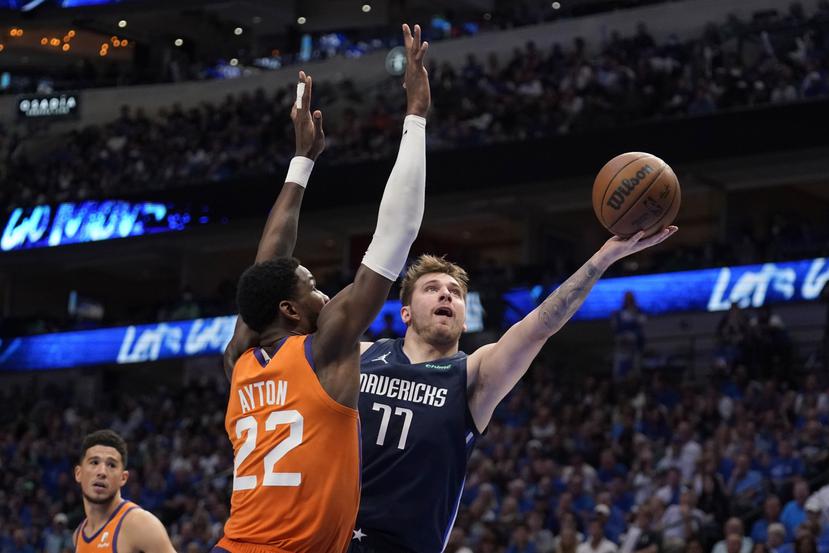 Luka Doncic (77) encesta por los Mavericks de Dallas pese a la marca de Deandre Ayton (22), de los Suns de Phoenix. (Tony Gutierrez)