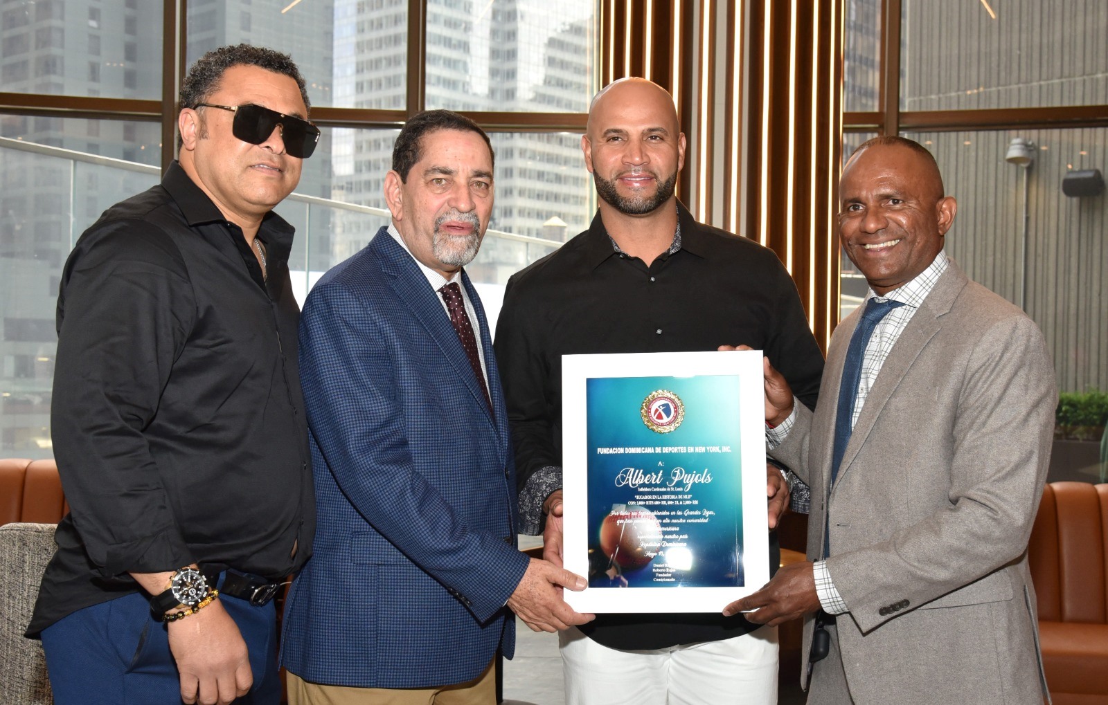 Daniel Reyes, presidente de la FDDNY, reconoce la carrera profesional de Albert Pujols en la MLB. En la gráfica aparecen el cónsul NY Eligio Jáquez y el ex pelotero Willy Otáñez.