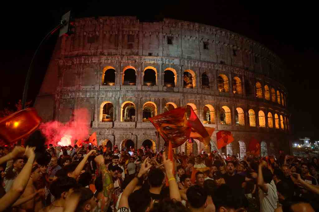 Hinchas de la Roma celebra frente al Coliseo tras la victoria en la final de la Europa Conference League ante Feyenoord, en Tirana, Albania, el 25 de mayo de 2022. (AP/GREGORIO BORGIA)