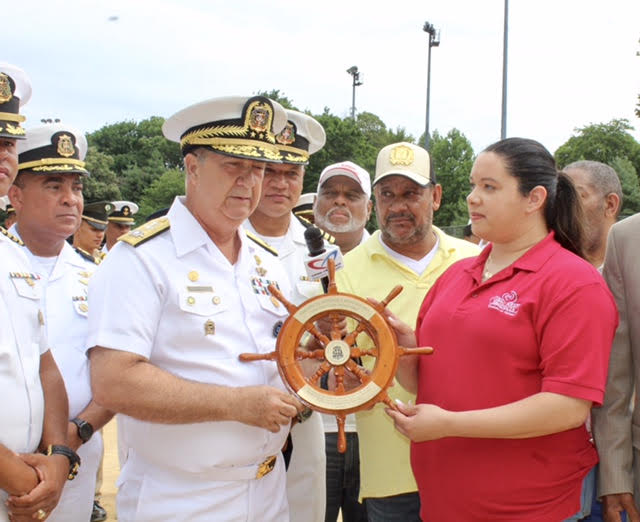 El comandante general de la Armada, vicealmirante Ramón Gustavo Betances Hernández, hace entrega a la joven Jaline Horta, un símbolo de esa institución.