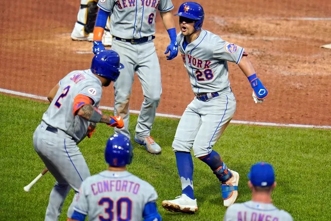 J.D. Davis (28), de los Mets de Nueva York, celebra con Dominic Smith (2) cuando regresa al banquillo luego de conectar un jonrón de dos carreras ante el lanzador abridor de los Piratas de Pittsburgh, Wil Crowe, durante la cuarta entrada de un juego de béisbol en Pittsburgh, el sábado. 17 de julio de 2021. (Foto AP/Gene J. Puskar) Gene J. Puskar, AP