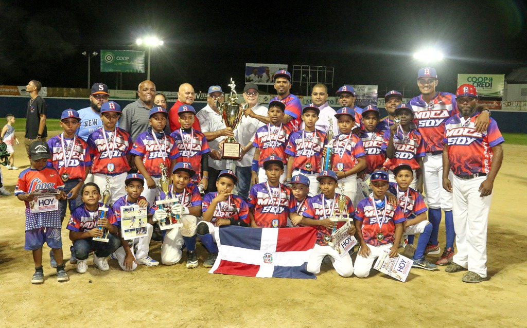MOCA, novena anfitriona fue la ganadora en la división de 10 años. David Lantigua, Santana Martínez y Miguel Bueno, entregan el trofeo de campeón. Figuran Argenis Betances, el ministro Encarnación, Taveras y Víctor Compres.