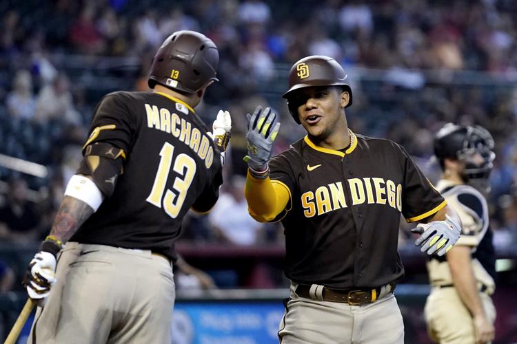 Juan Soto, de los Padres de San Diego, a la derecha, celebra su jonrón contra los Diamondbacks de Arizona con Manny Machado (13) de los Padres durante la quinta entrada de un juego de béisbol en Phoenix, el domingo 18 de septiembre de 2022.