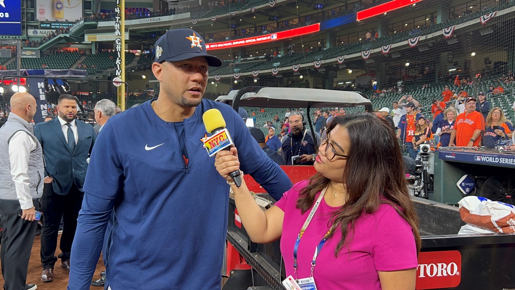 Arlenis J. Peña es capatada conversando con el pelotero cubano Yuli Gurriel.