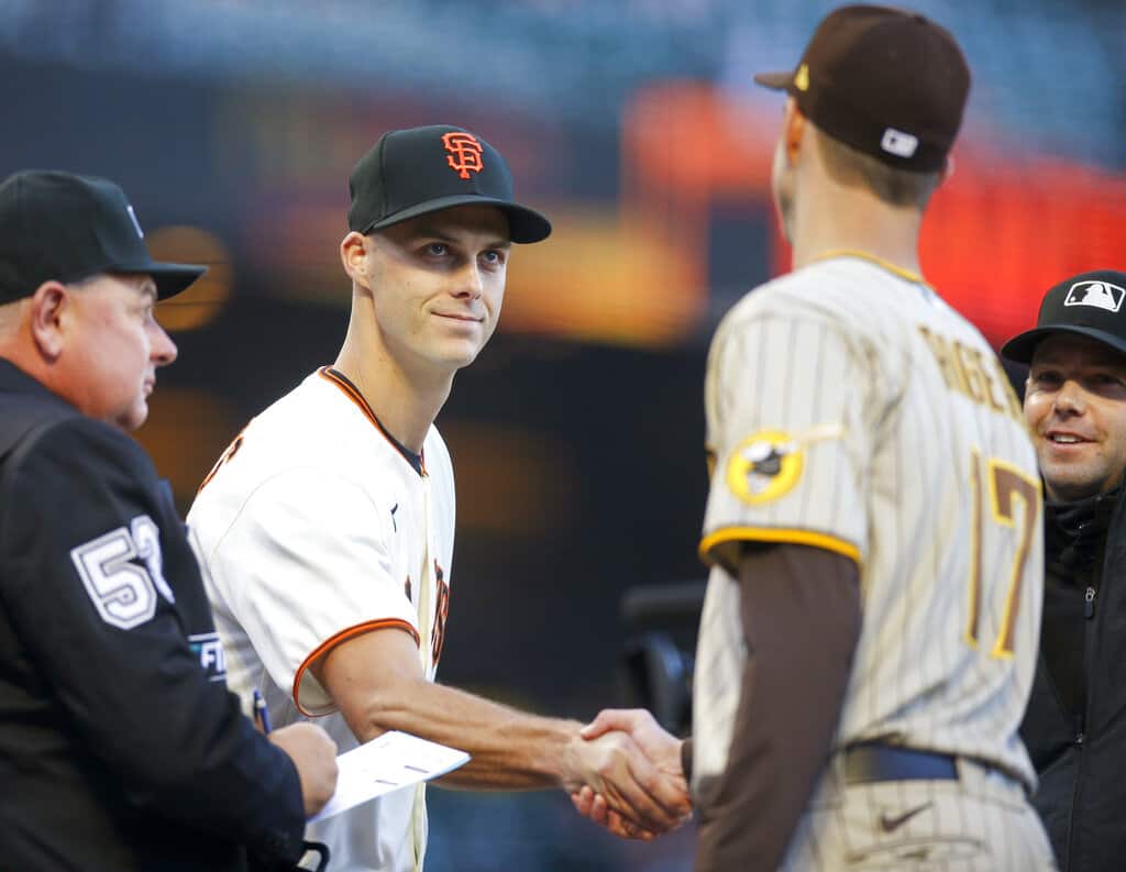Tyler Rogers (71) de los Gigantes de San Francisco le da la mano a su hermano Taylor Rogers (17) de los Padres de San Diego mientras intercambian alineaciones antes de su partido en San Francisco, el lunes 11 de abril de 2022. (NHAT V. MEYER/BAY AREA NEWS GROUP VIA AP)