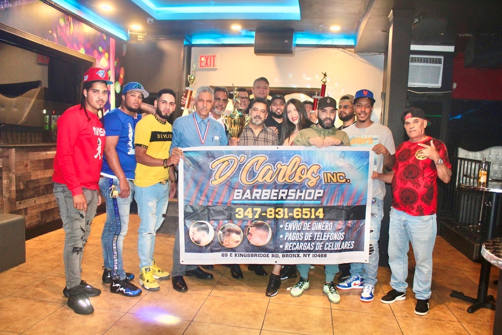 Los campeones D´ Carlos Barber Shop, encabezado por su dirigente y sponsor Carlos Sánchez, reciben la copa de campeón de parte de Miguel Ortega.