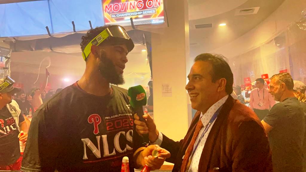 Neftalí Medina captando en diálogo con Seranthony Domínguez en la cueva de los Filis en el Citizens Bank Park