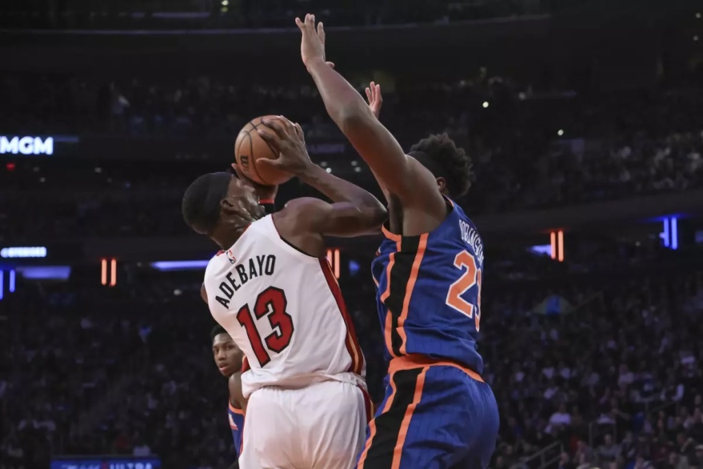 Bam Adebayo, del Heat de Miami, busca disparar frente a Mitchell Robinson, de los Knicks de Nueva York