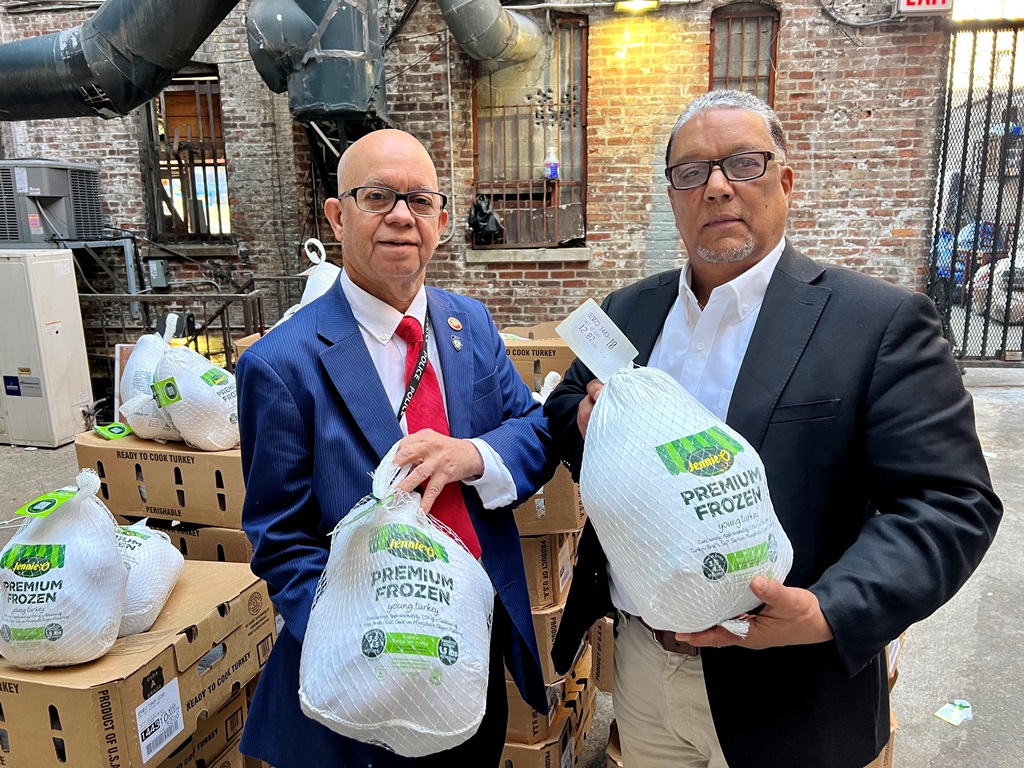 Persio Fernández, (37), presidente y Digno Hidalgo, (193 ), tesorero, posan con pavos de los que fueron repartidos este jueves.