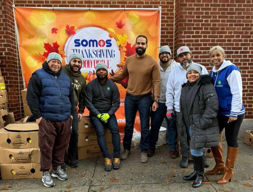 Alex Damirón, executive Vice President of Operations and Chief of Staff of SOMOS Innovations, (centro), aparece junto a parte del personal que entregaron pavos y comidas.