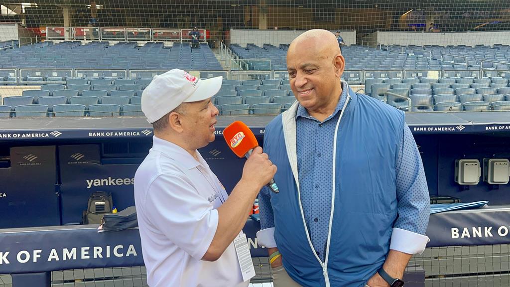 Agustín Zapata aborda a Omar Minaya en el Yankee Stadium.