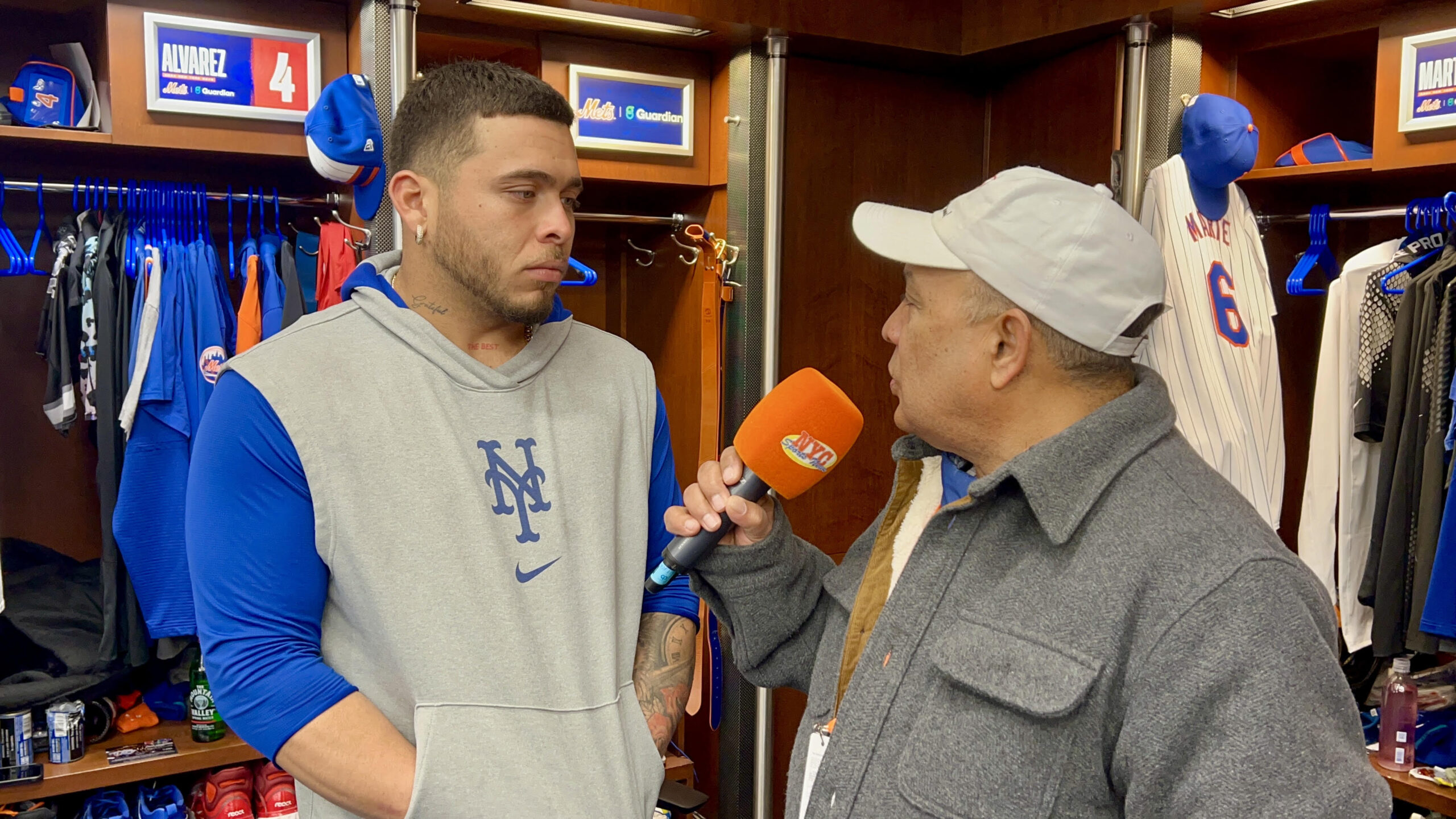 Francisco Álvarez escucha una pregunta de Agustín Zapata, mientras fue consultado en el clubhouse de los Mets en Citi Field.