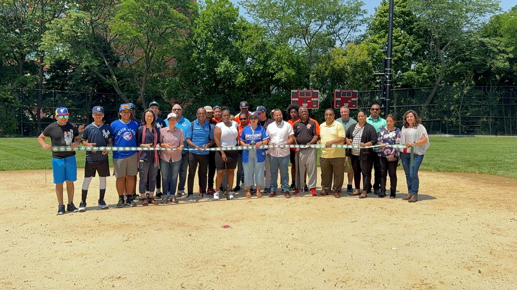 Jessenia Aponte, Comisionada de Parques en El Bronx; José M. Serrano, Senador, Distrito 29, El Bronx; Fannie Guest, coordinadora de permisos de parques y dirigentes deportivos, dan el corte de cinta para dejar inaugurados los reconstruidos campos de béisbol y la cancha de baloncesto de Franz Sigel Park.