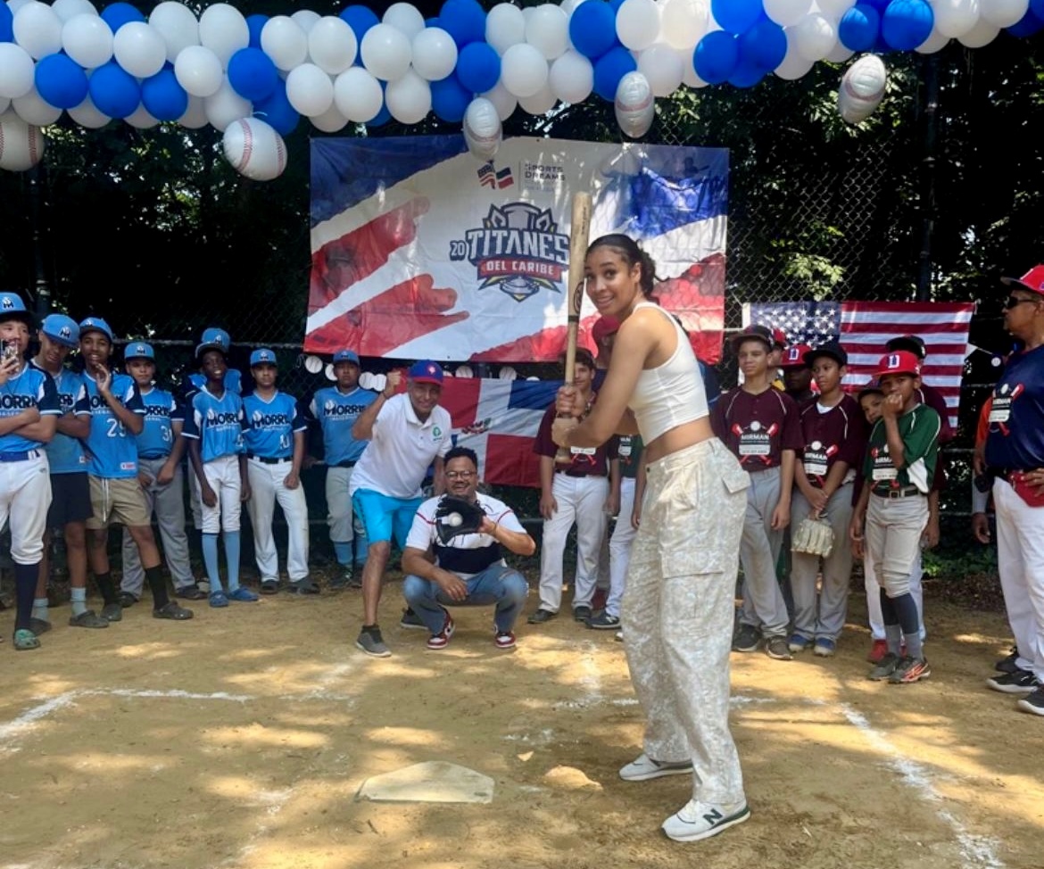 Esmery Dahiana Martínez, primera dominicana en la WNBA, funge de bateadora, mientras Robert Uribe, primer alcalde dominicano en Arizona, recibe y el inmortal del deporte dominicano (Baloncesto) Manolo Prince, fue el árbitro invitado.