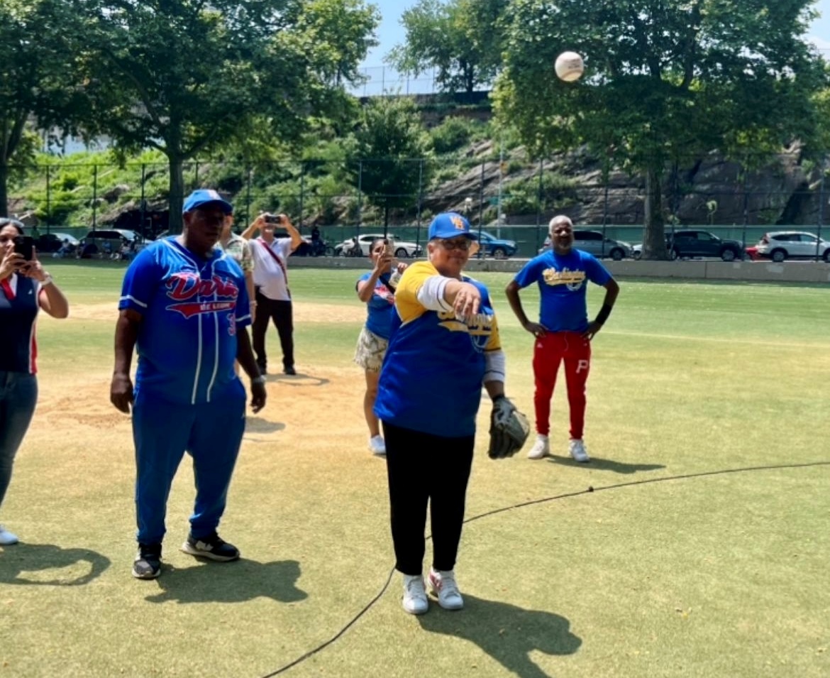 la licenciada Soledad Hiciano, directora ejecutiva de la Asociación de Dominicanos Progresistas (ACDP), y a quien está dedicado el certamen de béisbol, realiza el lanzamiento de la primera bola.