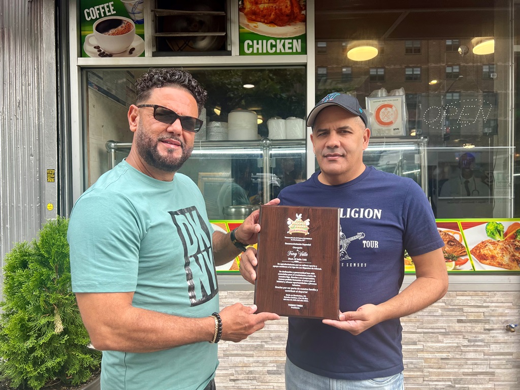 Yorki Tineo, (Izq.), realiza la entrega de una placa a Félix Rosario, de 156 El Valle Restaurant, Manhattan.