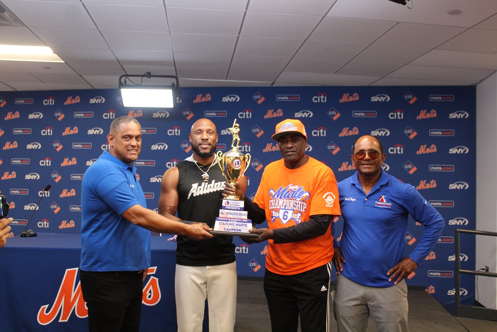 Roberto Rojas y Starling Marte, acompañado de Daniel Reyes, entregan el trofeo de campeón al manager Mariano Pool.