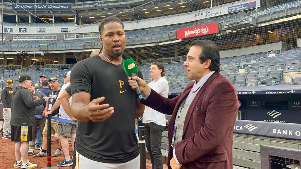 Luis L. Ortíz, de los Piratas dialoga con Neftalí Medina en Yankee Stadium.