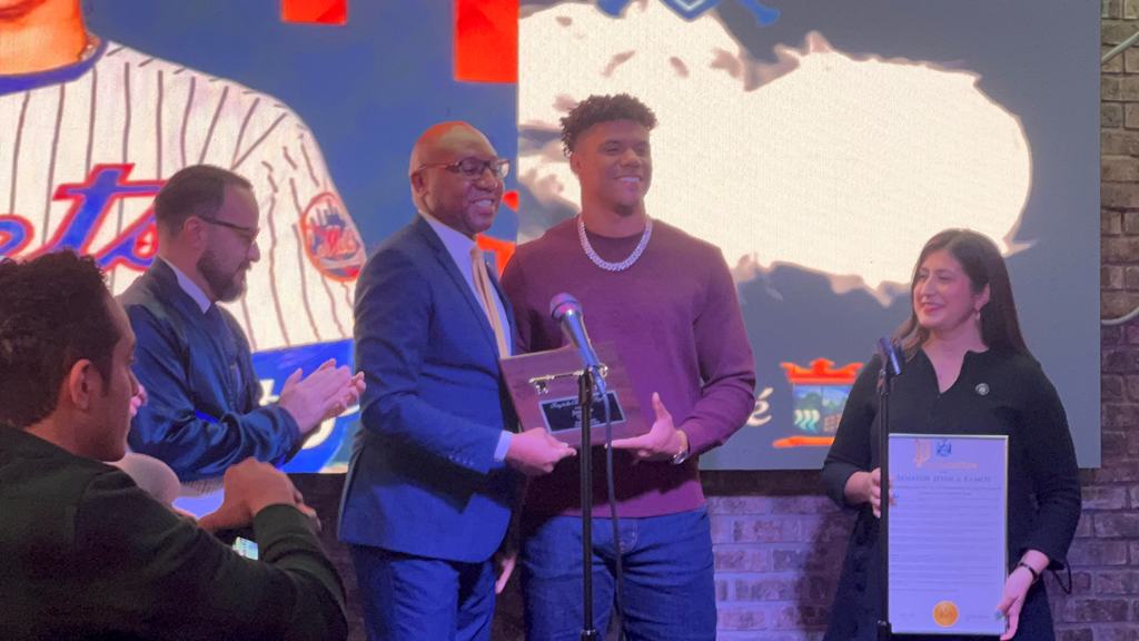 Donovan Richards Jr., Presidente del condado de Queens, entrega una placa a Juan Soto.