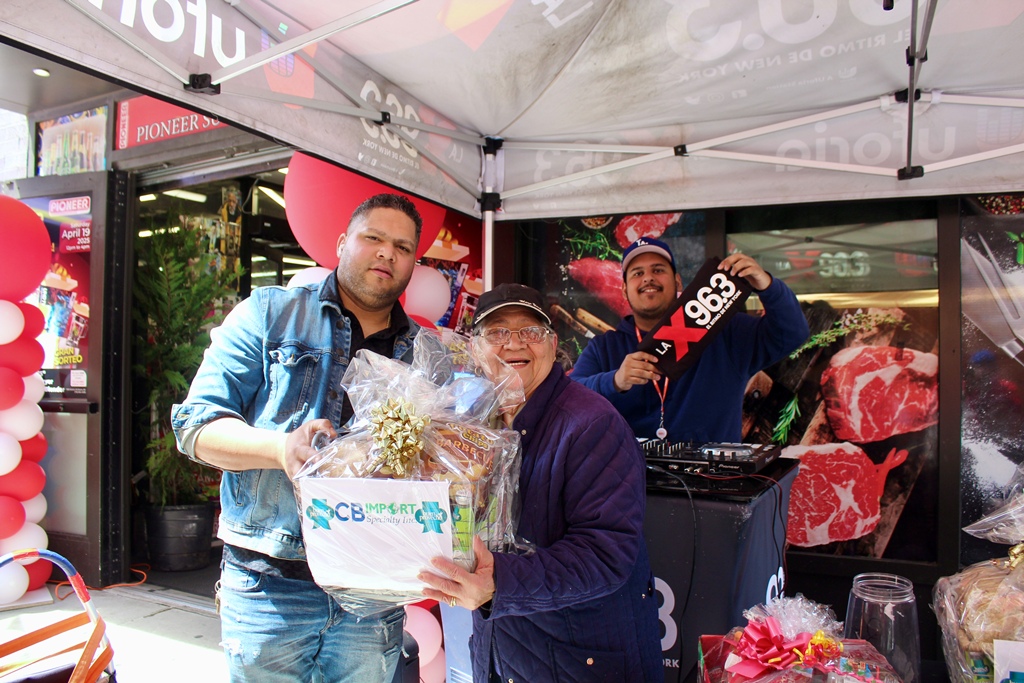 El manager general de Pionner Supermarket, Aníbal Tejada, festeja junto a una señora que acudió a la fiesta aniversaria y se llevó una canasta de CB Import.