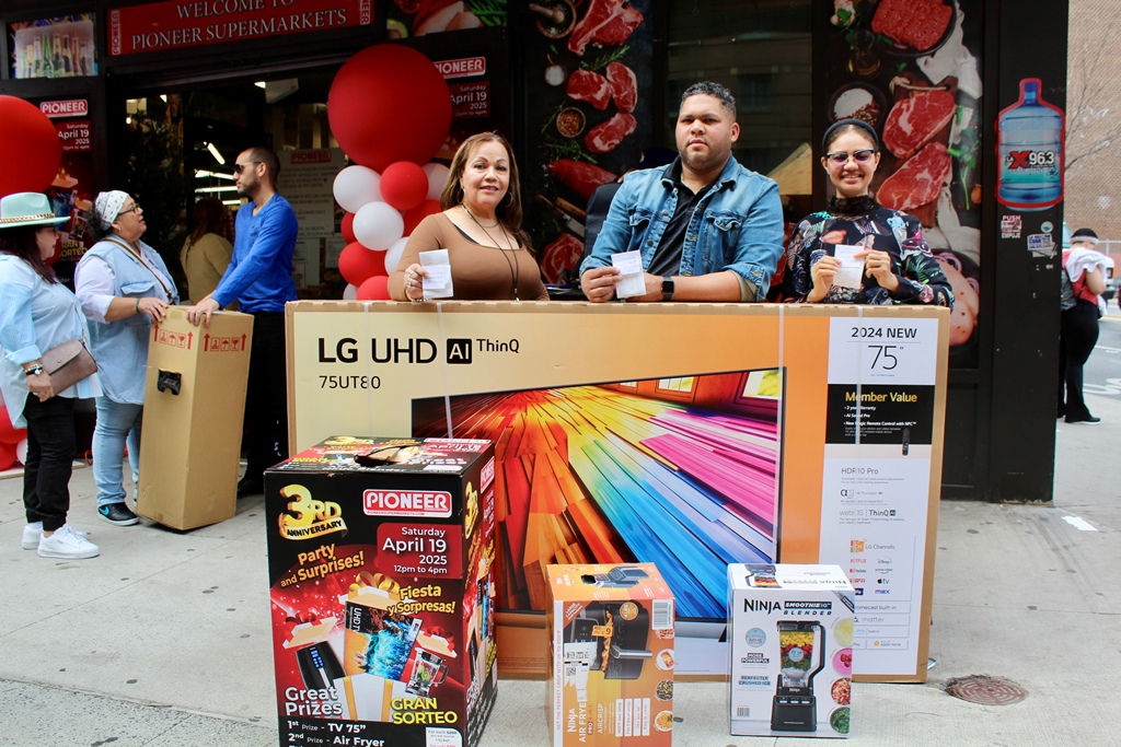 El manager general de Pionner Supermarket, Aníbal Tejada, acompañado de Rosa Paulino y Honey Mejía, presentan el televisor de 75 pulgadas y otros aparatos electrónicos que fueron rifados.