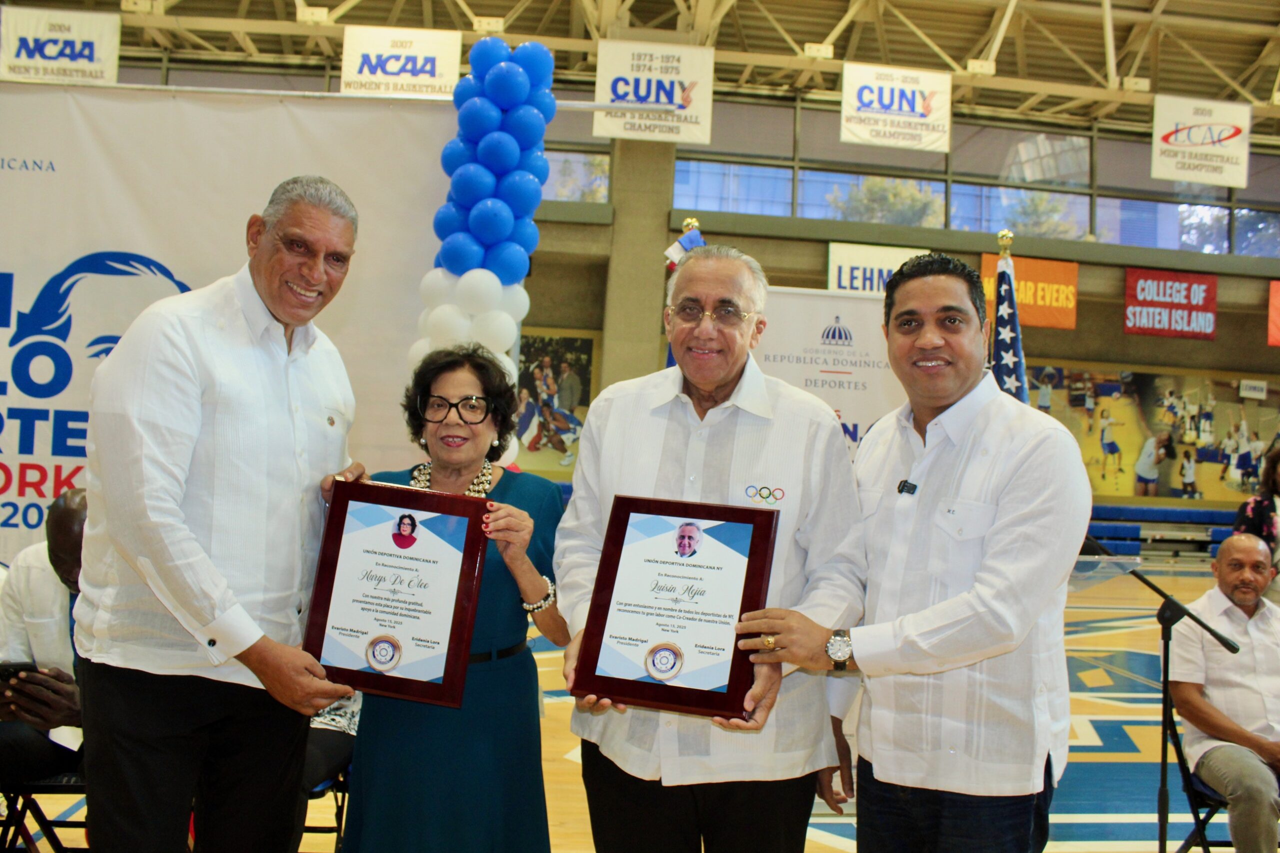 El Cónsul en Nueva York, Jesús Vásquez, (izq.) y el Ministro de Deportes, Kelvin Cruz, (der.), reconocen a Nurys de Óleo y a Luisín Mejía, a quienes están dedicados los juegos.