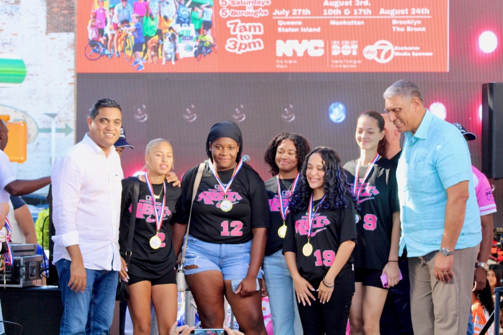 La RBI de Paterson, New Jersey, campeonas de softbol molinete femenino, son galardonadas por Kelvin Cruz y Chu Vásquez.