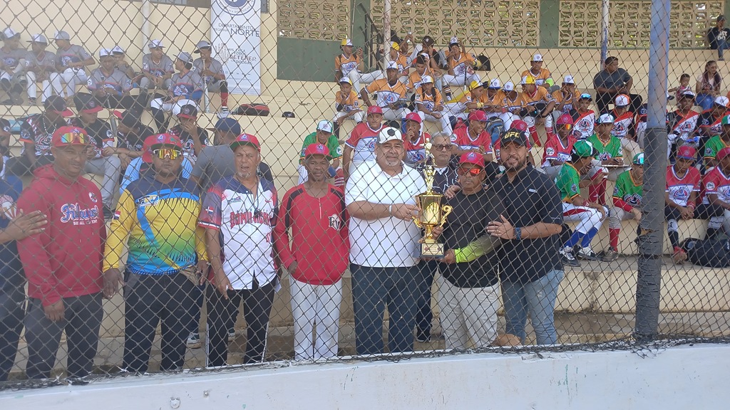 Dirigentes de béisbol de Moca, acompañan al licenciado Ariel Vásquez, presentando el trofeo que estará en juego en el evento que lleva su nombre.