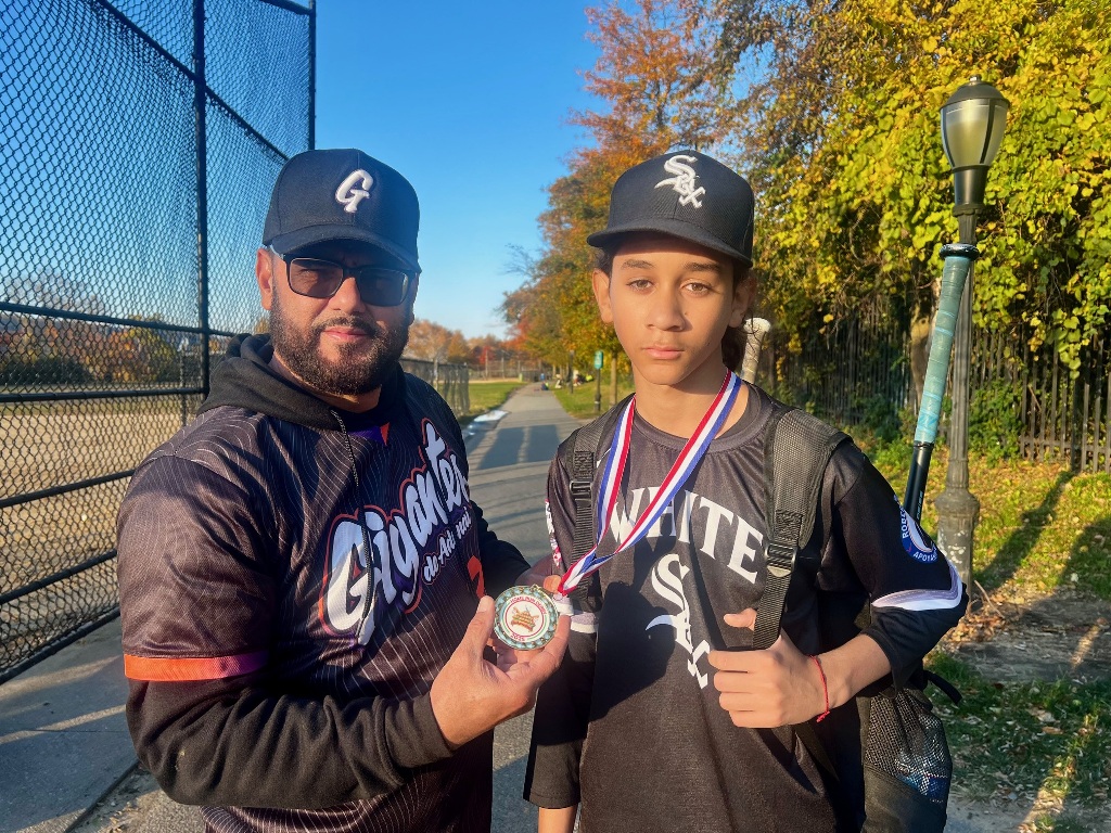 Yorkis Tineo, entrega una medalla de competidor a uno de los atletas.
