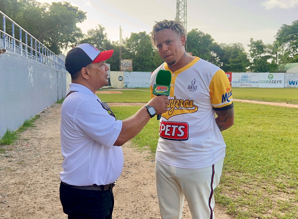 Yairo Muñoz conversa con Agustín Zapata durante una entrevista realizada en el Estadio Bragañita García, donde destacó el ambiente de unidad en Los Granjeros de Moca y su compromiso de ayudar al equipo a conquistar un nuevo campeonato.
