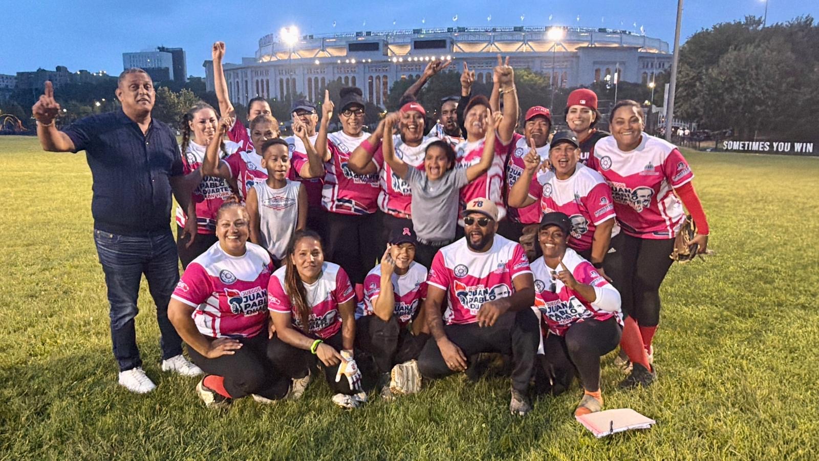 Roberto Rojas, a la izquierda, director general de los Juegos Juan Pablo Duarte, comparte con las integrantes de Las Quisqueya de New Jersey, campeonas del torneo de softbol chata femenino.