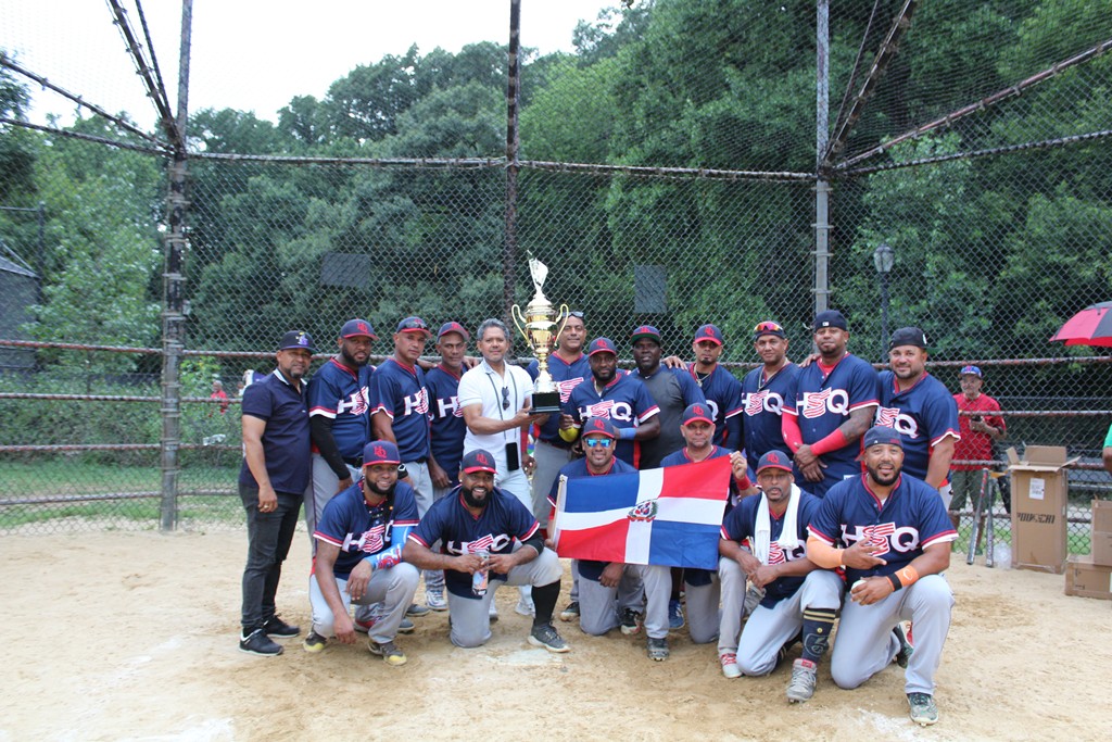 Félix Quiñones entrega la Copa Hermandad Quisqueyana al dirigente campeón Pedro Rondón, quien aparece junto a los jugadores del conjunto monarca tras conquistar la edición 32 del torneo de softbol 2026.
