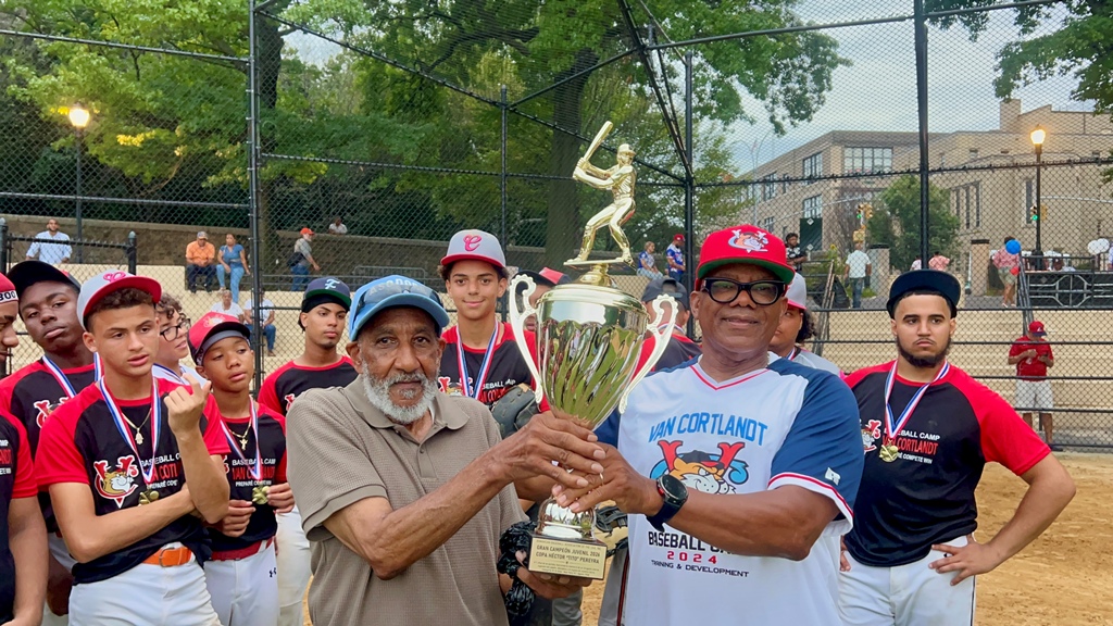 Héctor O’Neal, a la izquierda, entrega la copa de campeón al dirigente Jhonny Arias, quien la recibe visiblemente emocionado y feliz por la conquista del título.