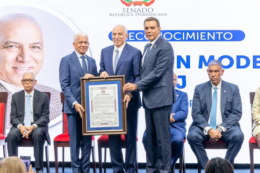 El presidente del Senado, Ricardo de los Santos, y el senador de la provincia Espaillat, Carlos Gómez, entregan al doctor Ramón Tallaj el pergamino de reconocimiento otorgado por el Congreso Nacional de la República Dominicana por sus valiosos aportes a la medicina y su trayectoria de servicio a la comunidad.