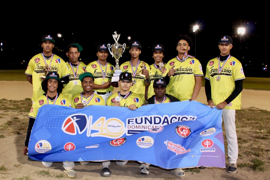 Integrantes de Bedford Baseball League, campeones de la categoría 15-16 años, exhiben con orgullo el trofeo conquistado tras una brillante actuación en los Juegos de la Comunidad 2026.