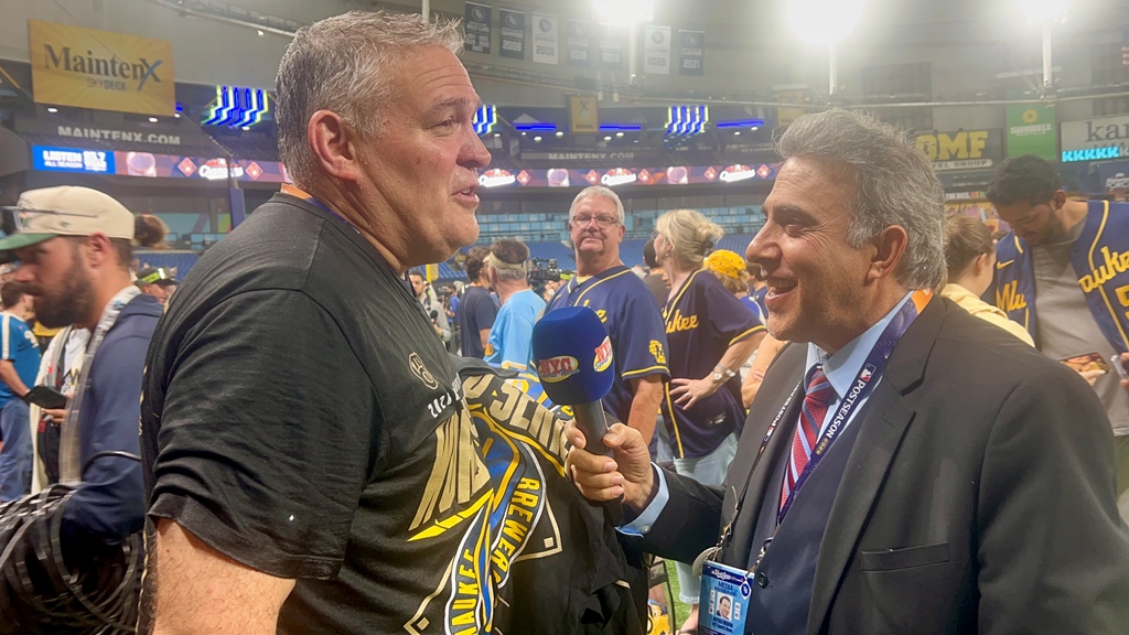 Dan Larrea, vicepresidente de Viajes y Operaciones del Clubhouse de los Cerveceros de Milwaukee, celebra eufórico la conquista del campeonato y, en medio de la histórica celebración en el terreno de juego, sostiene una interesante conversación con Neftalí Medina.