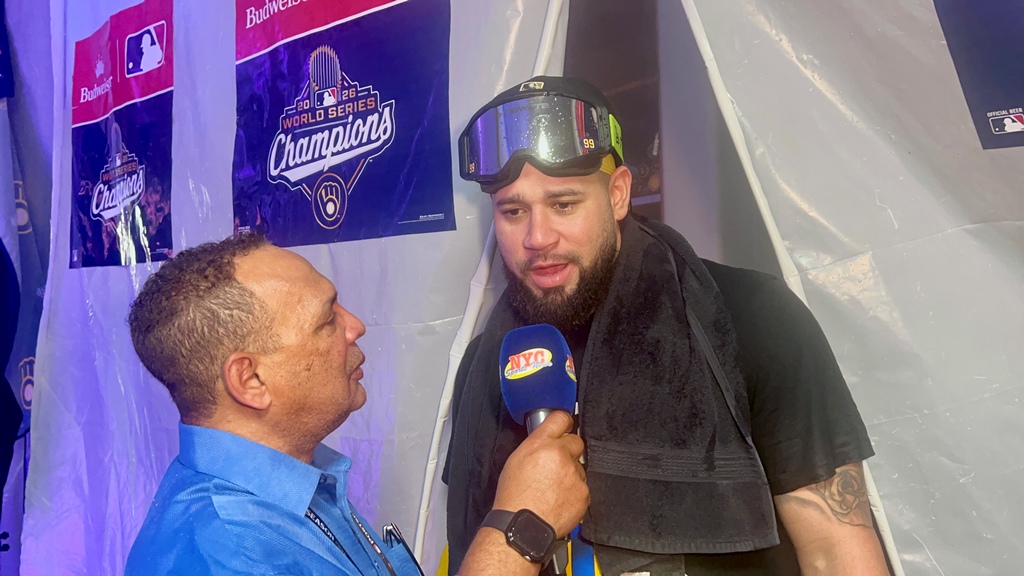 Agustín Zapata aborda a Gary Sánchez, quien luce jubiloso en la cueva de los Cerveceros de Milwaukee, celebrando la conquista del campeonato de la Serie Mundial y la primera corona de su carrera en las Grandes Ligas.